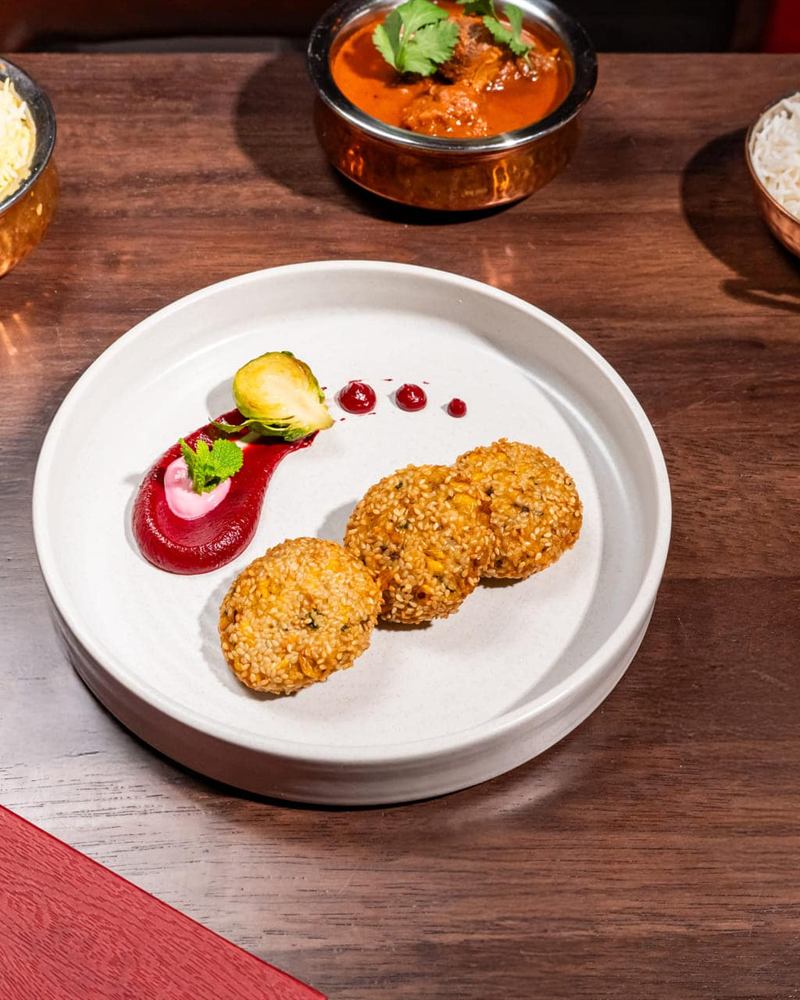 A plated dessert course beside the Holi menu