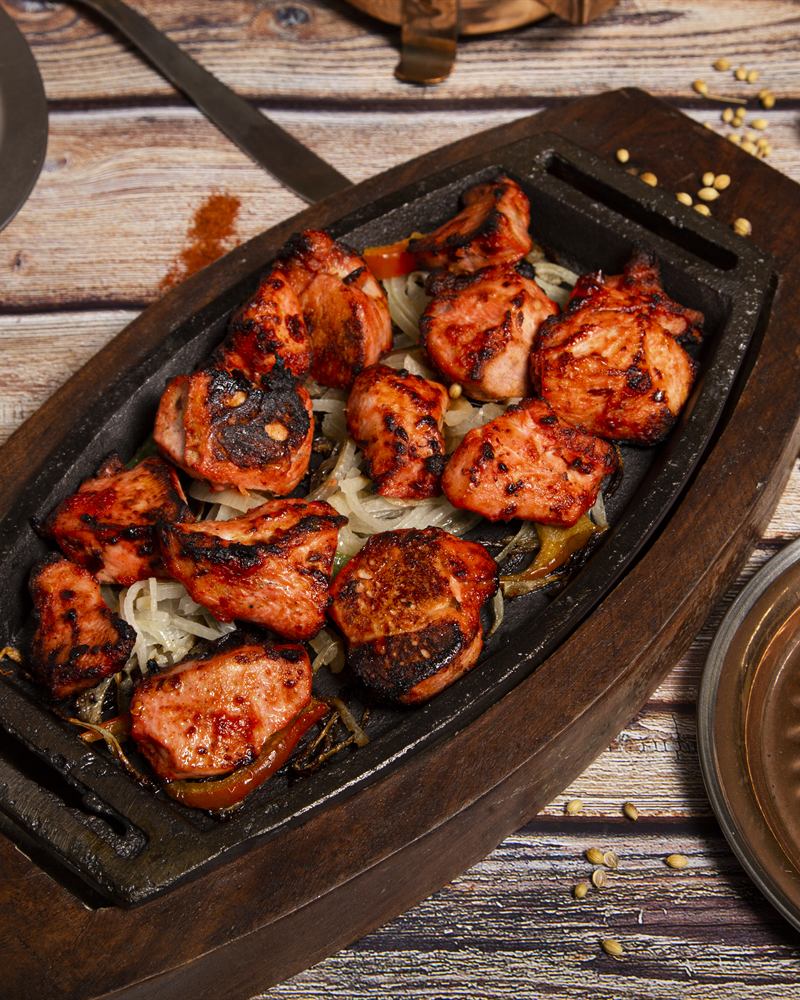 Tandoori chicken resting on cast iron